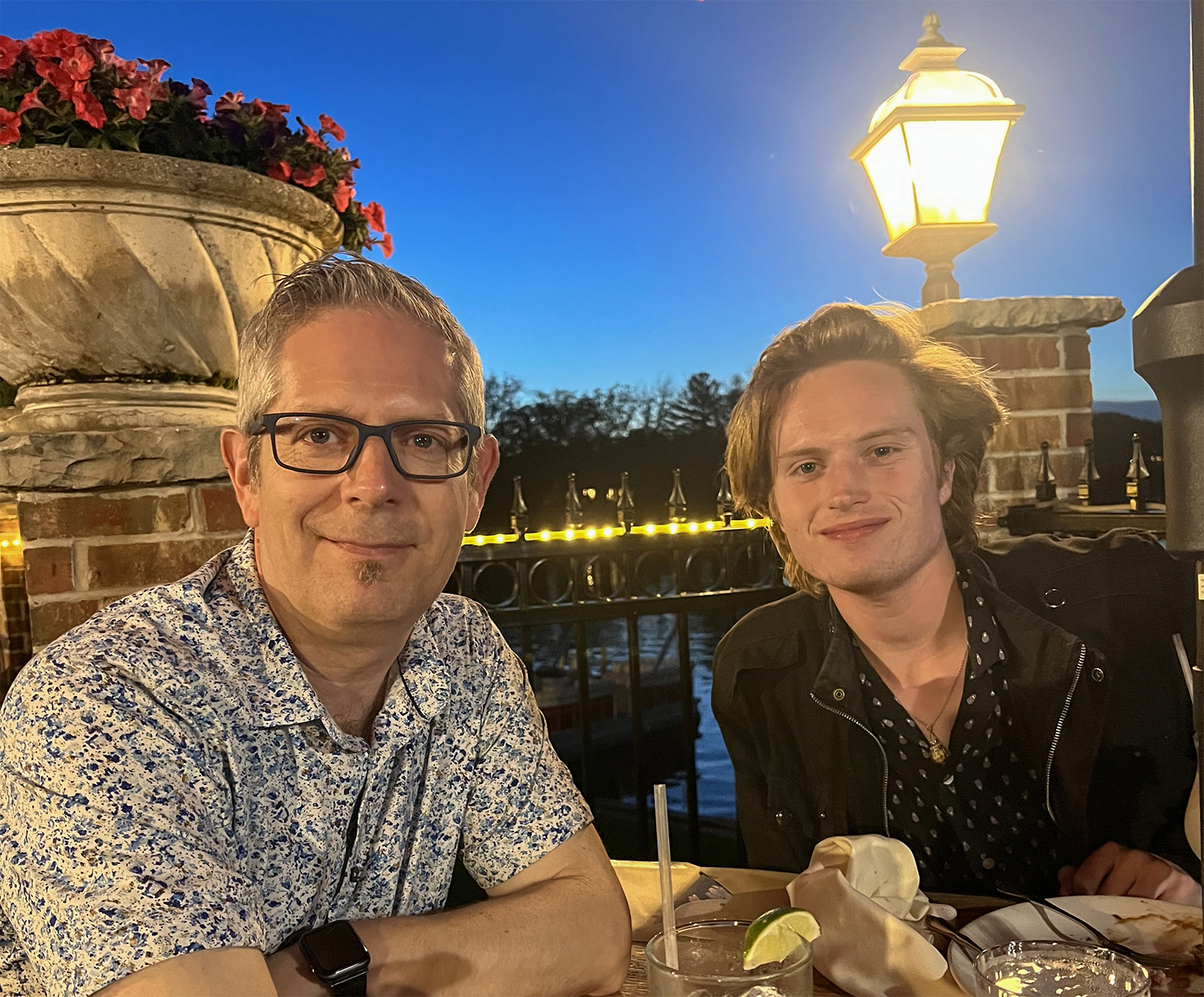 Matt and his son Vaughn at a riverside table on a summer evening.